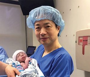John Zhang met de baby die het DNA van drie ouders heeft